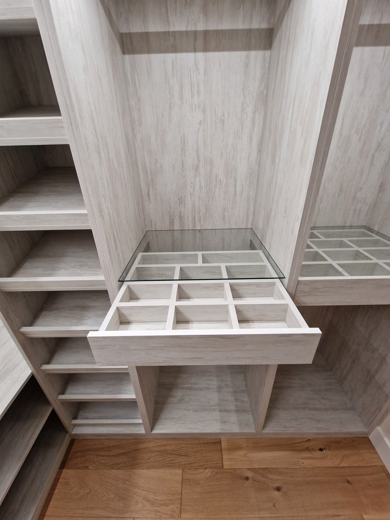 Divided accessory drawer beneath a clear glass top