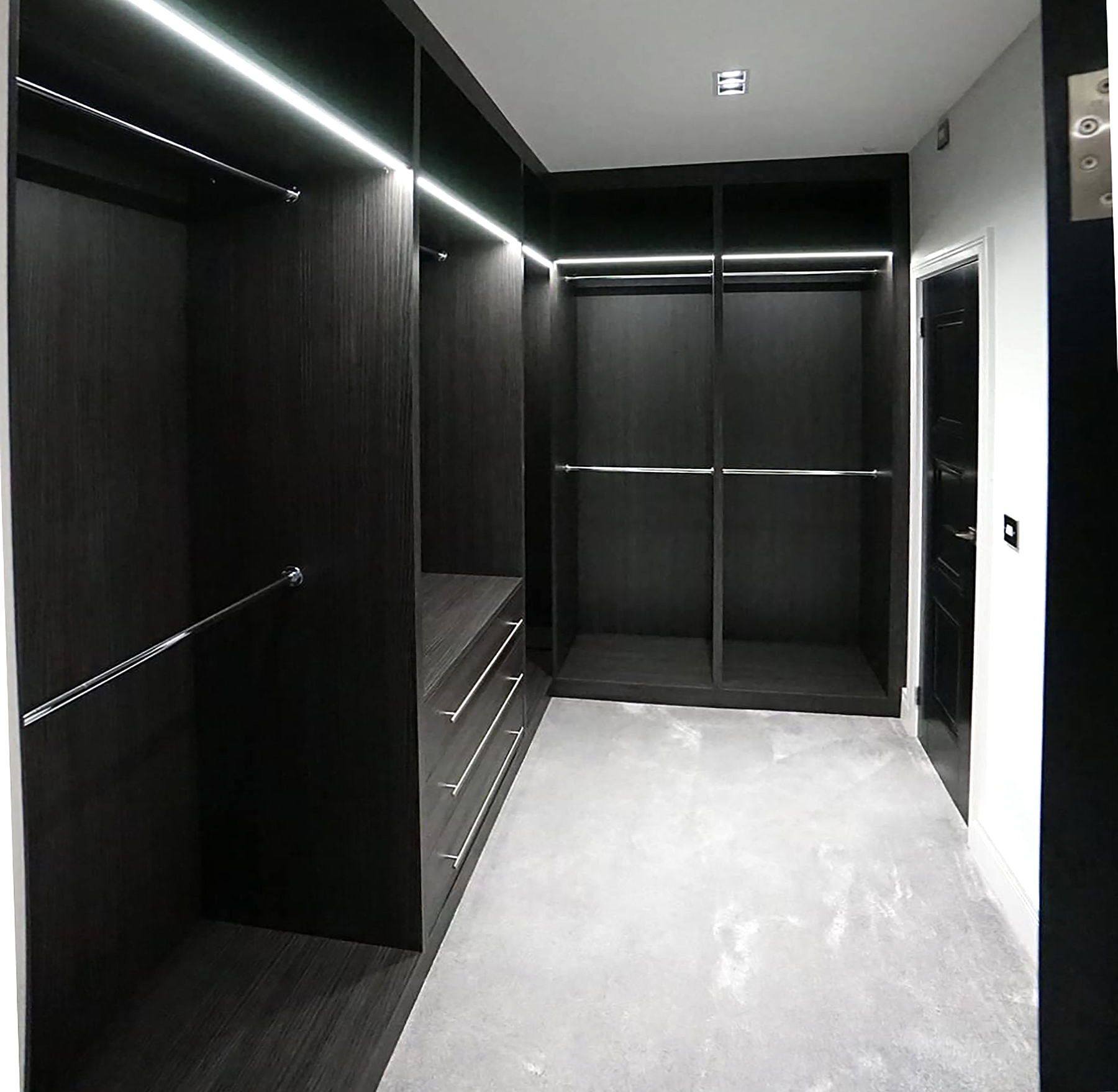 Black LED-lit walk-in wardrobe with drawers and hanging rails