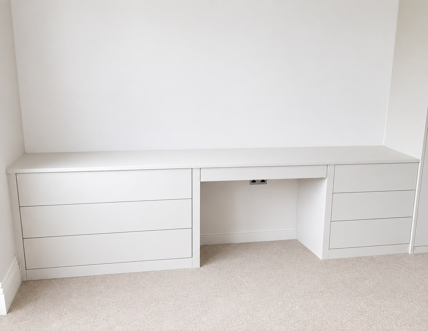 Completed wall-to-wall fitted study desk with integrated drawer storage