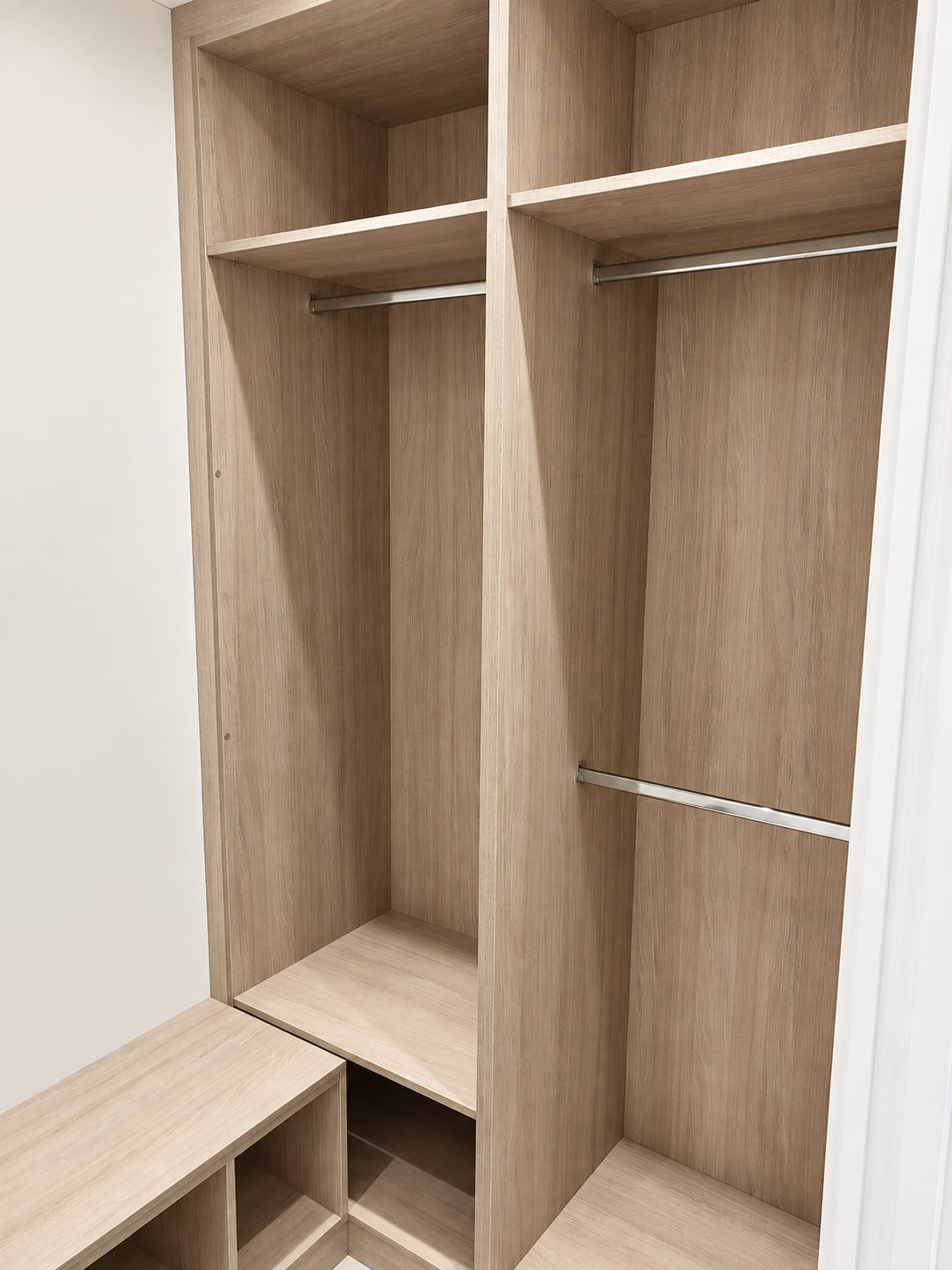 Corner hanging layout in a light woodgrain walk-in wardrobe