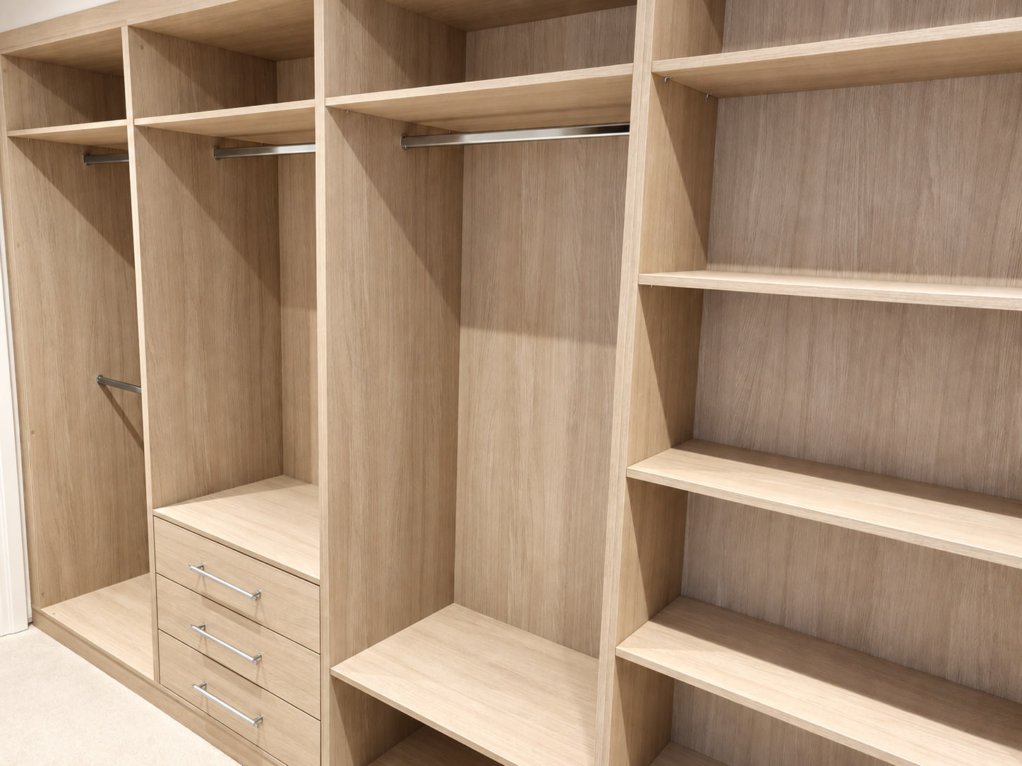 Light woodgrain walk-in wardrobe with drawers and shelves