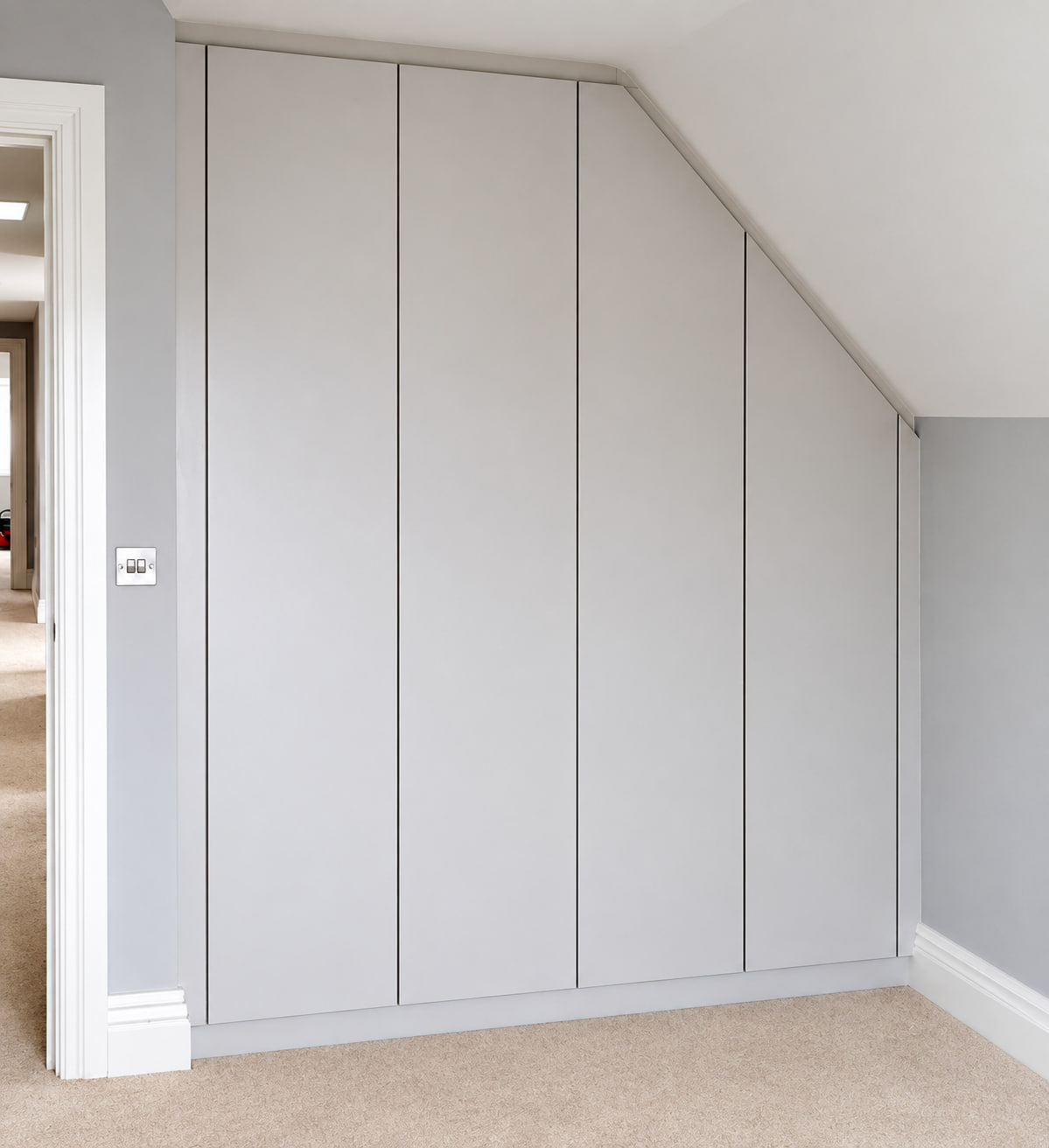 Angled fitted wardrobe door beneath a sloping ceiling