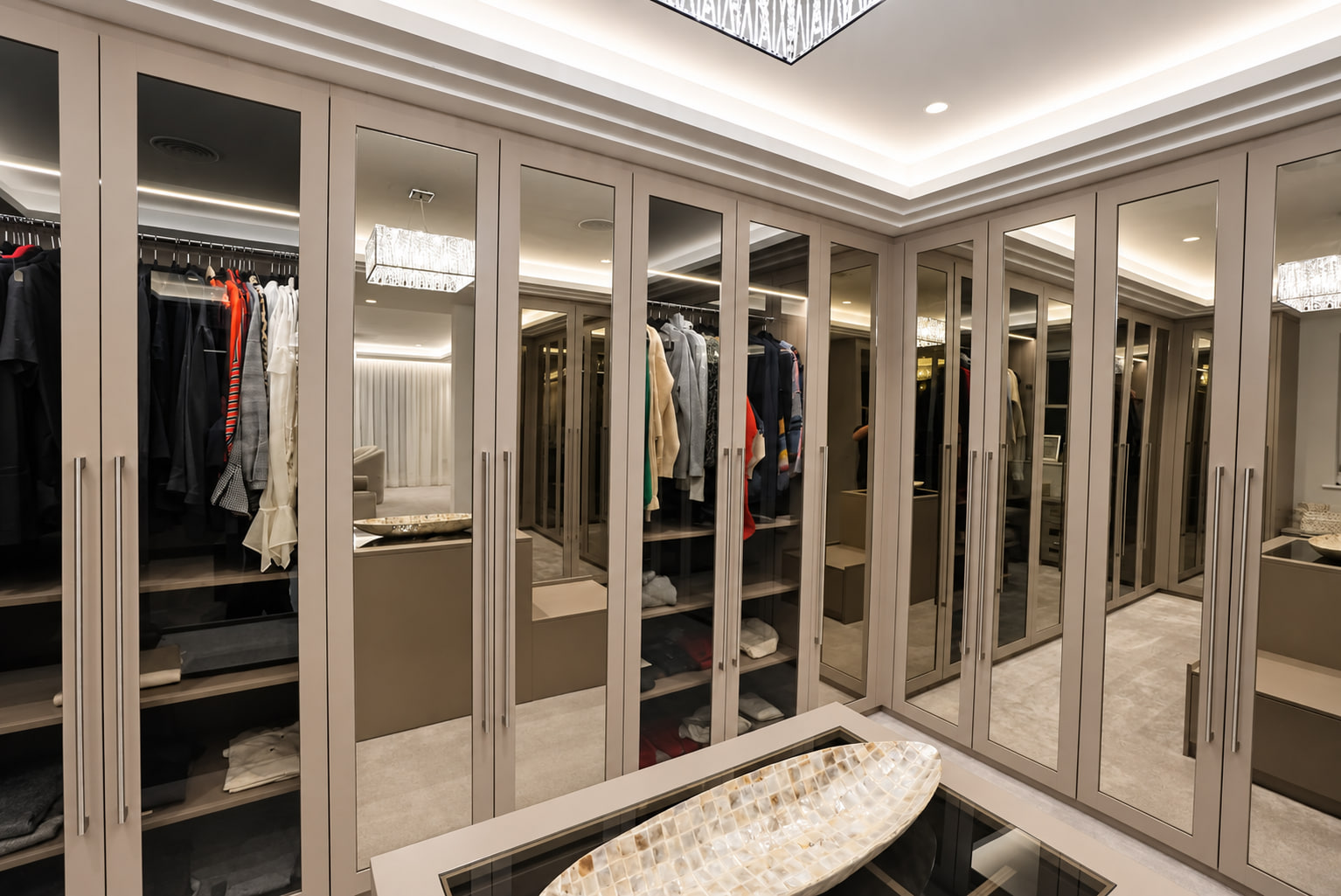 Taupe mirrored dressing room with glass-topped island