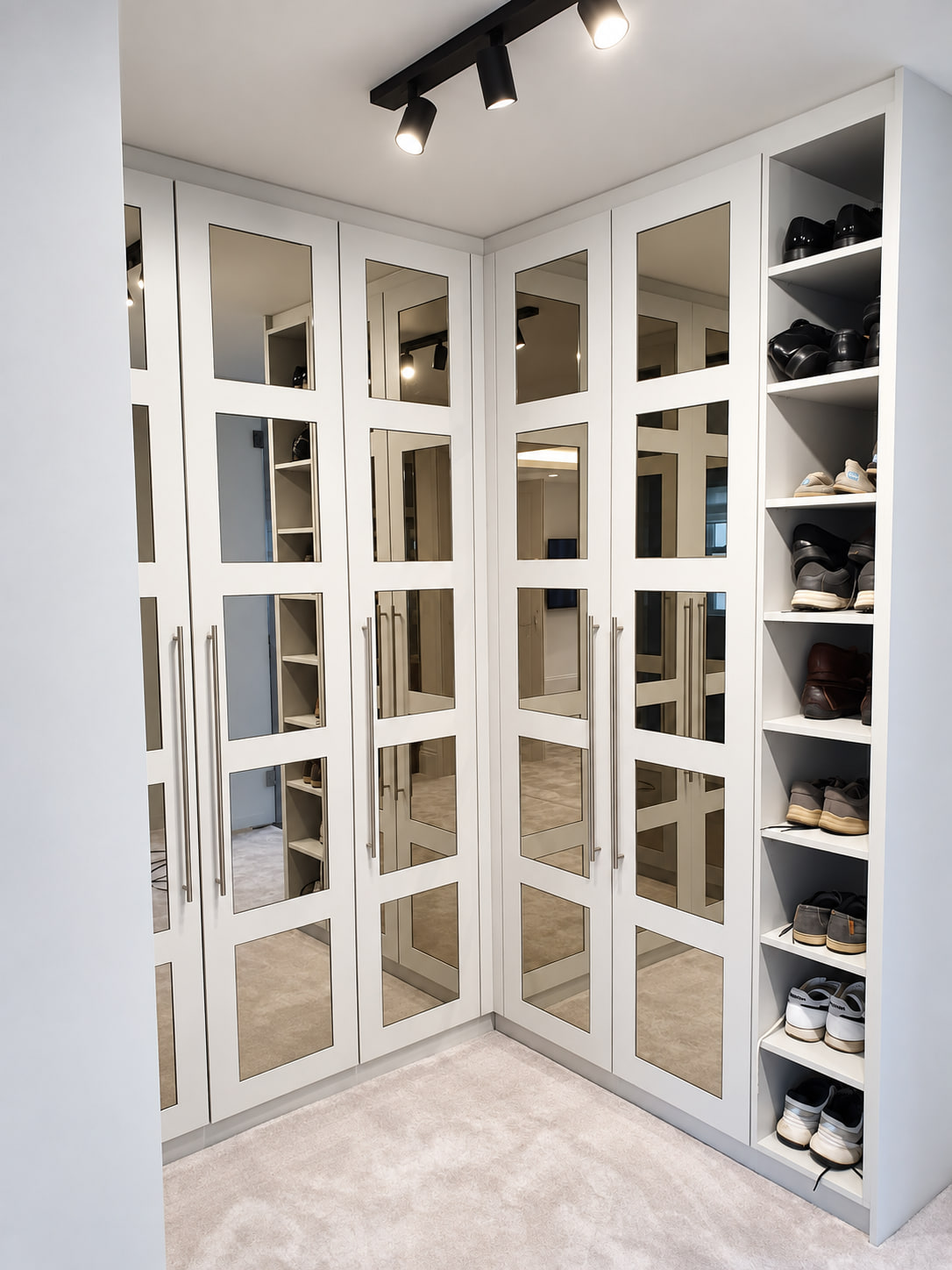 White mirrored walk-in wardrobe with open shoe storage