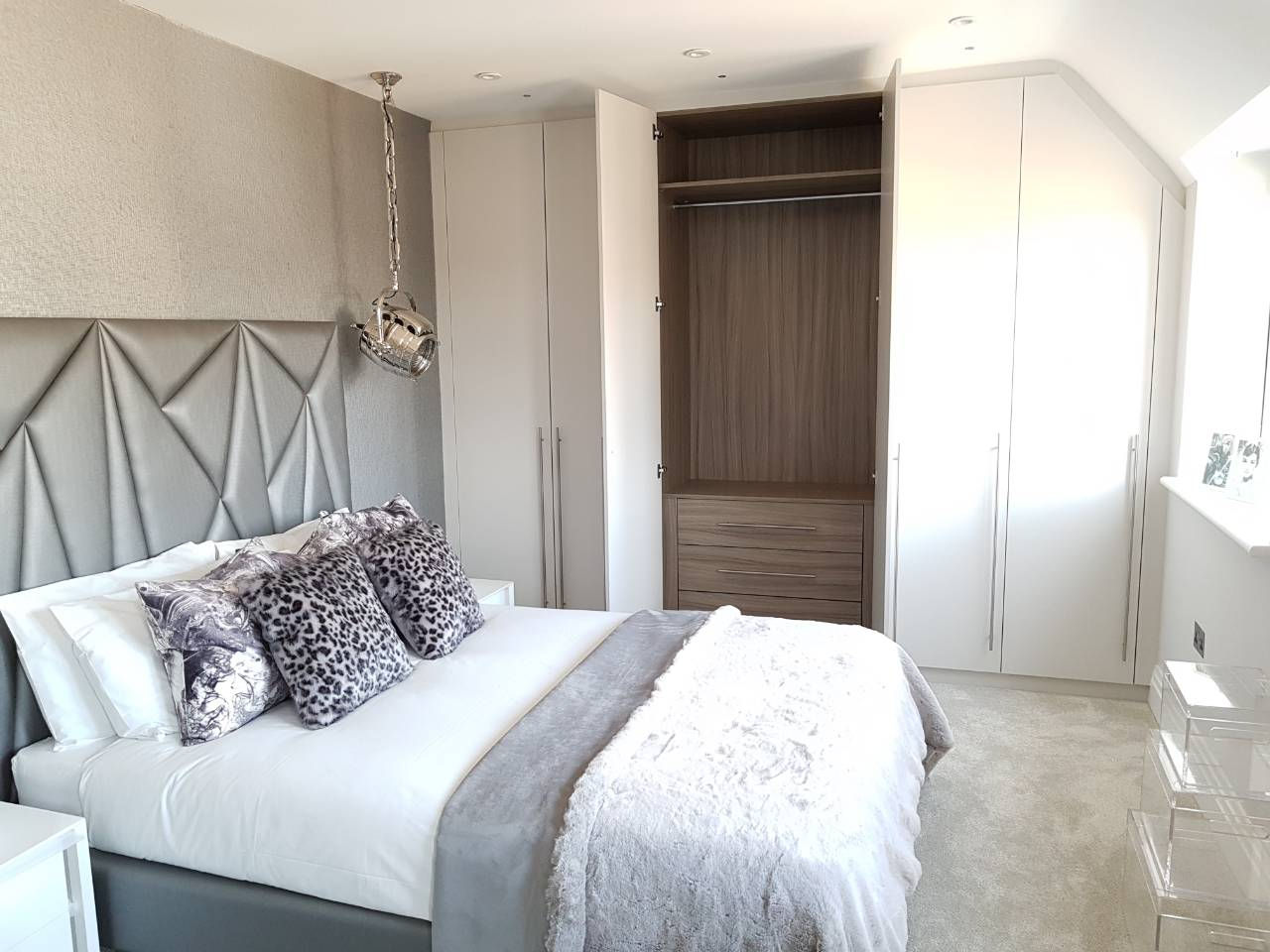 Open fitted wardrobe showing drawers, shelves and hanging zones