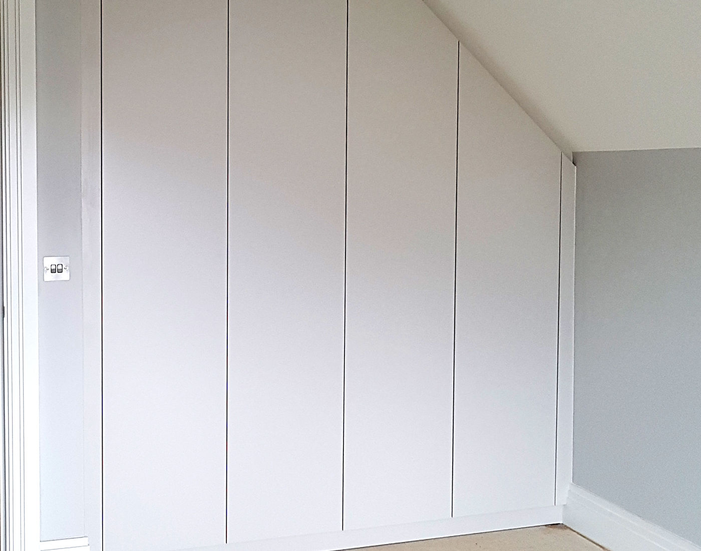 Completed fitted wardrobe doors shaped around a sloping ceiling
